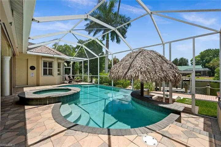 Pool surrounded by pavers and screened in