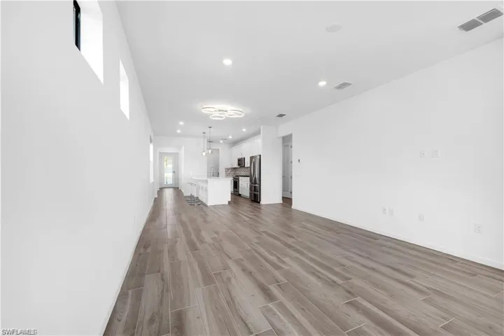 Unfurnished living room with wood finish floors and recessed lighting