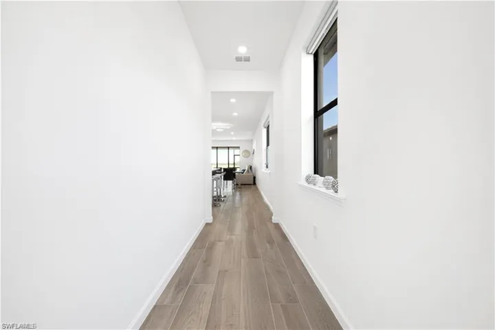 Hallway with wood finished floors and recessed lighting