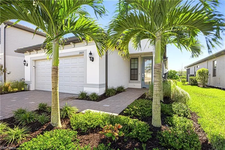 Ranch-style house with a garage, stucco siding, and driveway