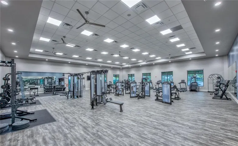 Workout area featuring a high drop ceiling, a ceiling fan, and recessed lighting