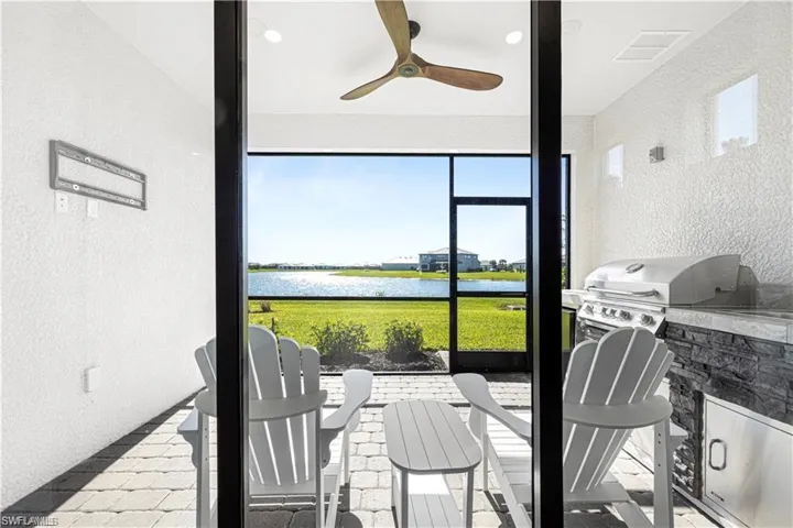 Sunroom / solarium featuring ceiling fan and a water view
