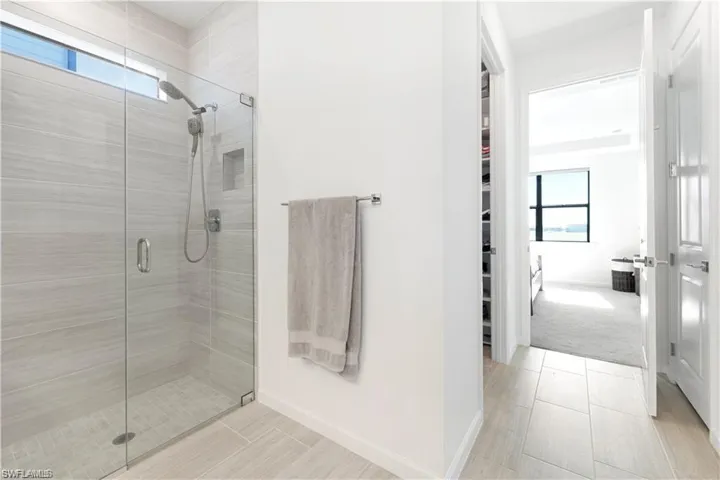 Full bath with a stall shower and a walk in closet