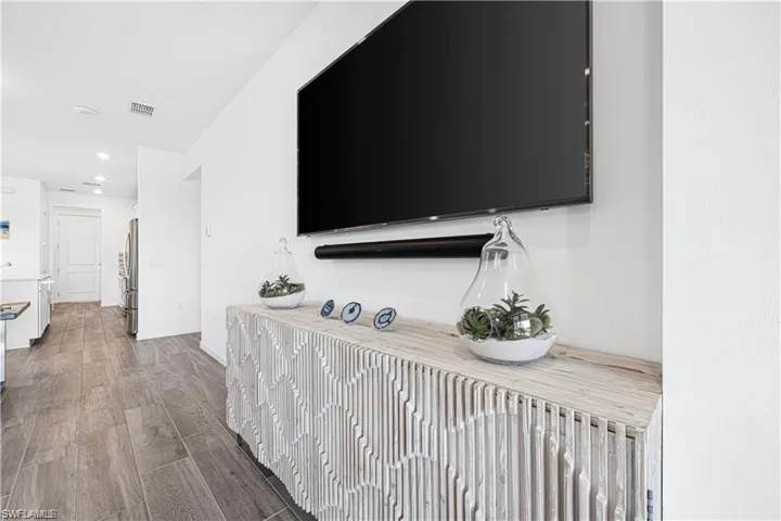Hallway with dark wood-style floors and recessed lighting