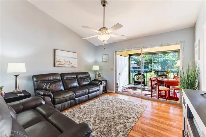 Living room featuring vaulted ceiling, light wood-type flooring, and ceiling fan