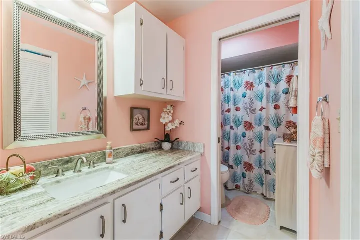 Bathroom featuring vanity, curtained shower, and light tile patterned floors