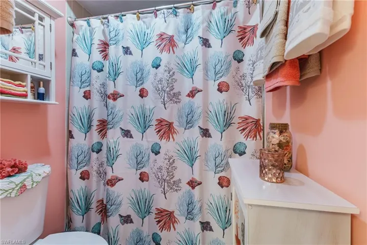 Full bathroom with a shower with shower curtain and toilet