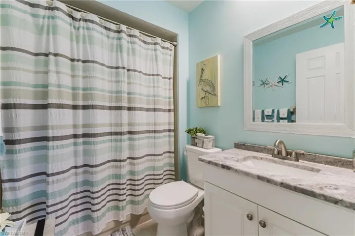 Bathroom with curtained shower and vanity