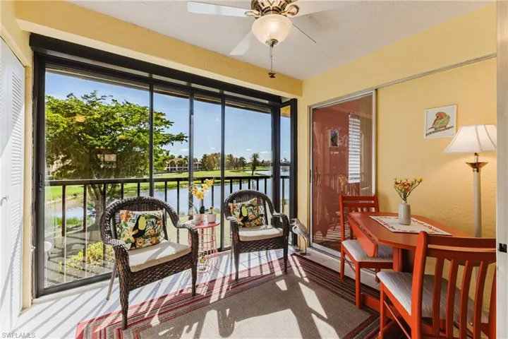 Sunroom / solarium featuring a water view, carpet floors, and a textured wall