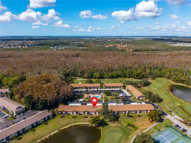 Drone / aerial view of a nearby body of water and a golf club