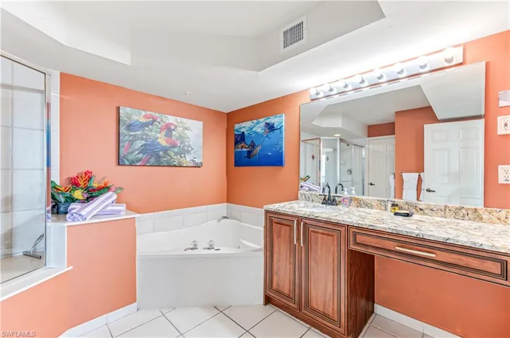 Bathroom featuring vanity, tile patterned flooring, and plus walk in shower - VIRTUALLY ENHANCED