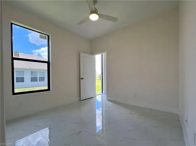 Empty room featuring ceiling fan and tile flooring