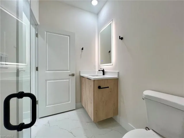 Bathroom featuring tile floors, large vanity, and toilet