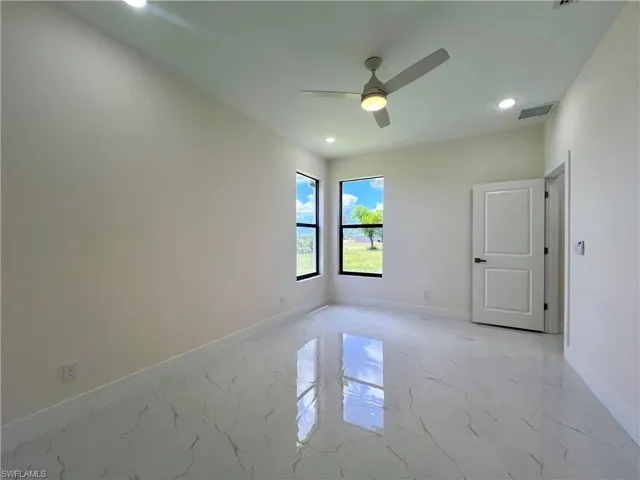 Tiled empty room featuring ceiling fan