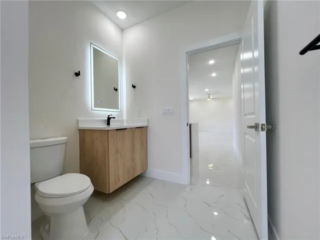 Bathroom with tile floors, toilet, and large vanity