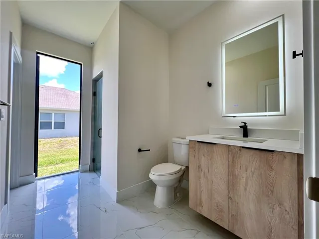 Bathroom featuring oversized vanity, toilet, and tile floors