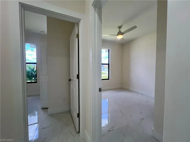 Corridor featuring plenty of natural light and light tile floors