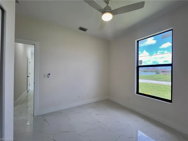 Empty room with tile floors and ceiling fan