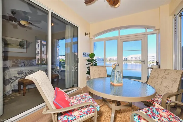 Sunroom with a water view and wood finished floors