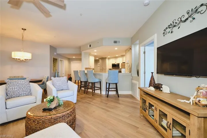 Living room with light wood-type flooring, ceiling fan, and recessed lighting