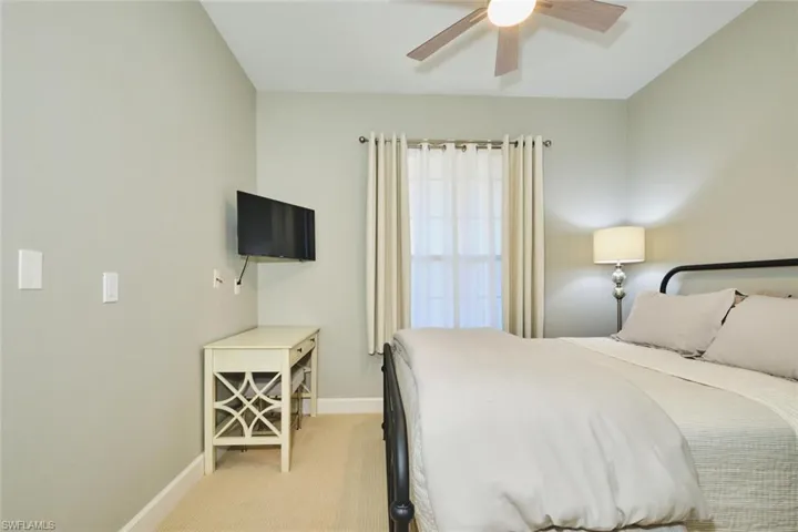 Bedroom with light colored carpet and ceiling fan