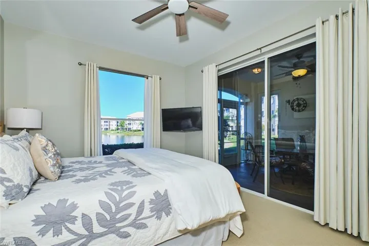 Carpeted bedroom featuring a ceiling fan, multiple windows, and access to outside