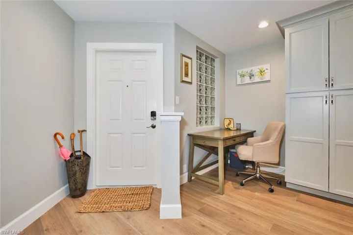 Office space with light wood-style flooring and recessed lighting