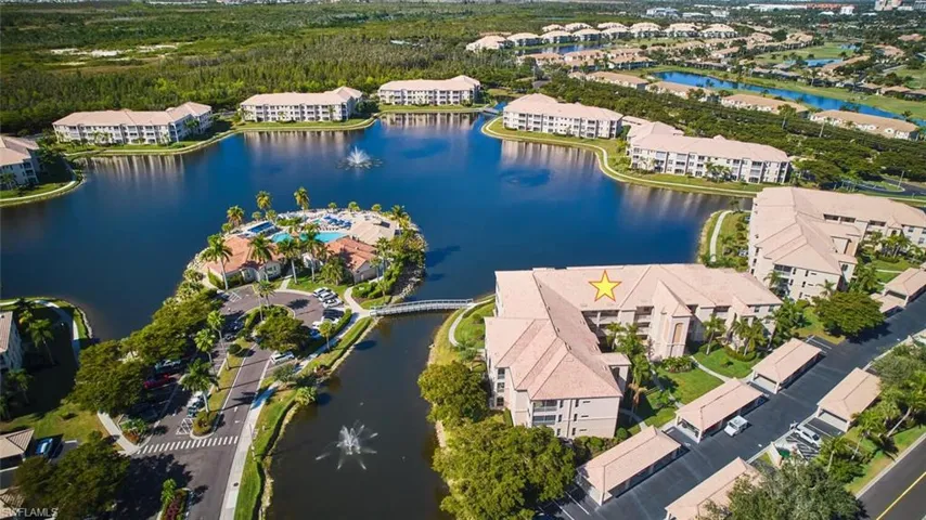 Aerial view of property and surrounding area featuring a nearby body of water and apartment complex / building