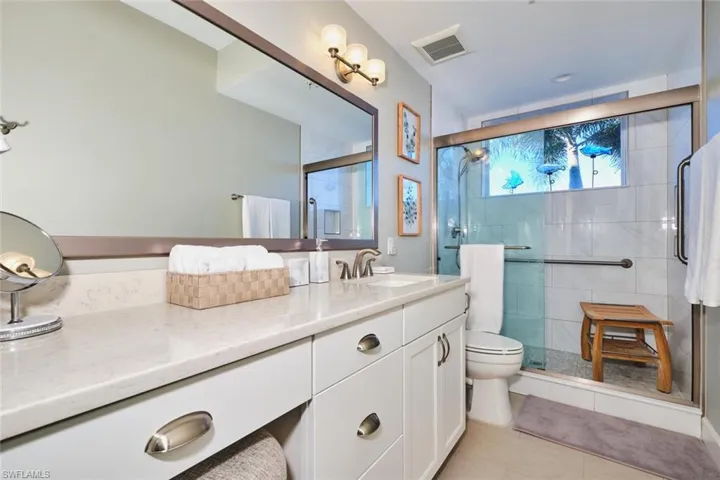 Bathroom featuring vanity, a stall shower, and light tile patterned floors