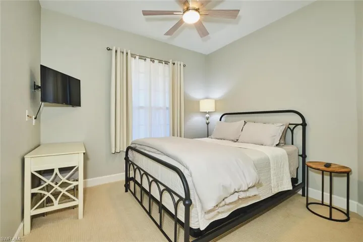 Bedroom with ceiling fan and light carpet