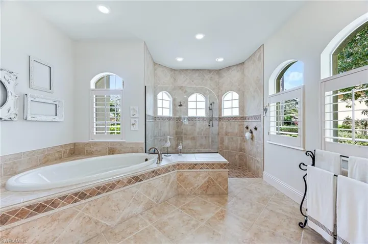 Bathroom with a bath, a walk in shower, tile patterned floors, and recessed lighting