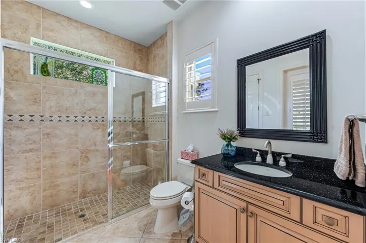 Bathroom featuring vanity, plenty of natural light, a stall shower, and tile patterned flooring