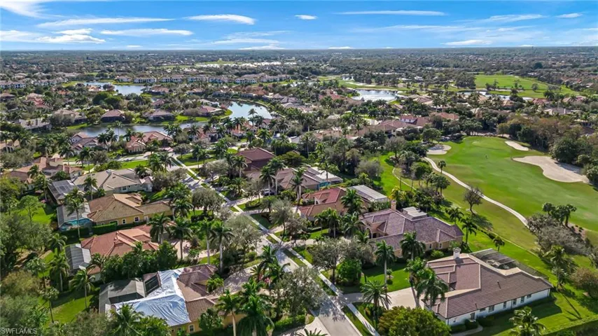 Aerial view of property and surrounding area featuring nearby suburban area and a large body of water