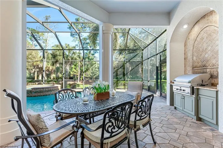 View of patio / terrace featuring area for grilling, an in-ground hot tub, glass enclosure, outdoor dining space, and an outdoor pool