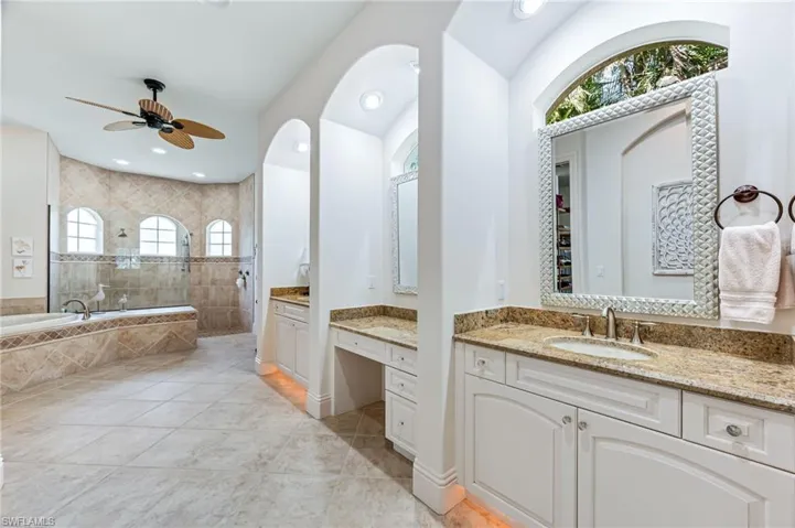 Full bath featuring a ceiling fan, walk in shower, tile patterned flooring, vanity, and a garden tub
