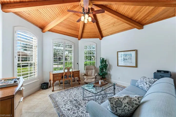Living room with wooden ceiling, light tile patterned floors, and a ceiling fan