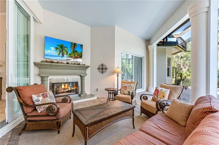 Living area featuring a glass covered fireplace and decorative columns