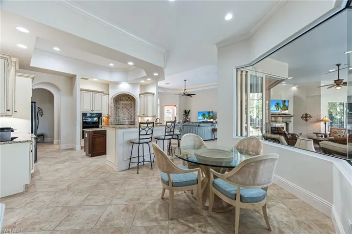 Dining space with a ceiling fan, crown molding, plenty of natural light, arched walkways, and recessed lighting