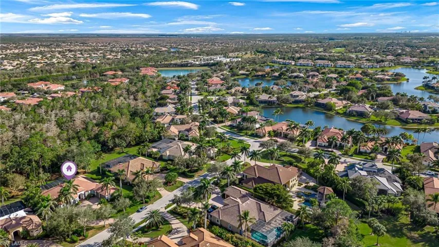 Aerial view of property and surrounding area featuring nearby suburban area and a large body of water