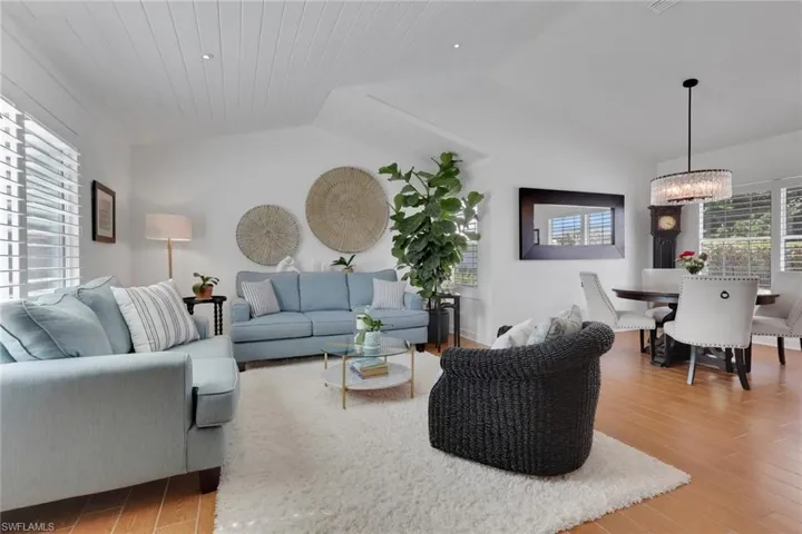 Living area featuring plenty of natural light, ceramic wood finished floors, tong & groove ceiling with new plantation shutters.