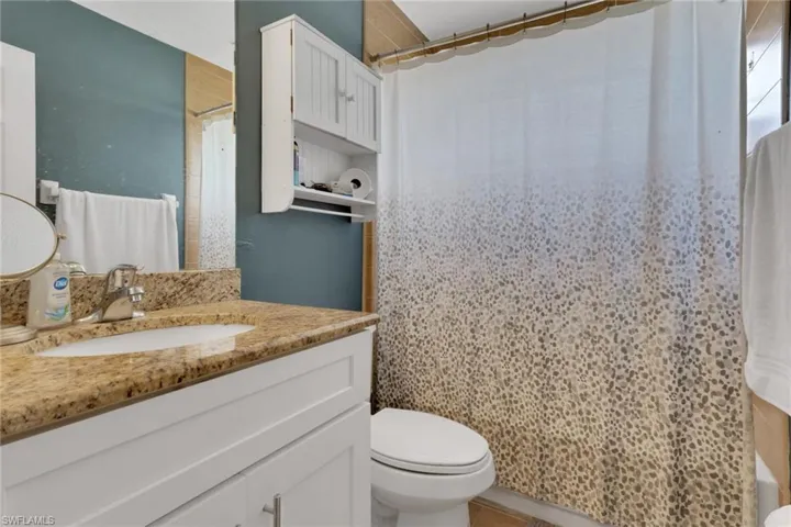 Carpeted bedroom with new ceiling fan and baseboards
