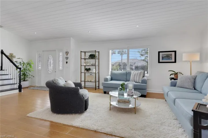 Living room featuring ceramic wood finished floors, recently painted stairs, tong & groove ceiling, recessed lighting and new plantation shutters