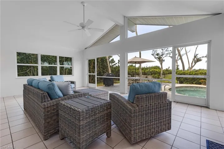 Sunroom with vaulted ceiling with beams and ceiling fan
