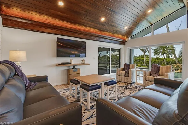 Living room featuring light wood-type flooring, lofted ceiling, and wooden ceiling