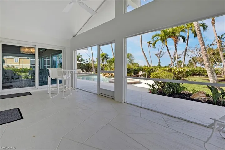 Unfurnished sunroom featuring ceiling fan, a healthy amount of sunlight, and vaulted ceiling
