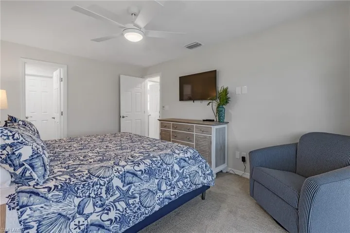 Carpeted bedroom featuring ceiling fan