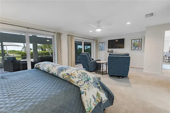 Carpeted bedroom featuring ceiling fan and access to outside