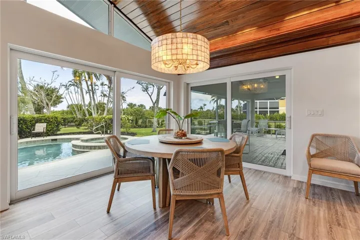 Sunroom / solarium with lofted ceiling, an inviting chandelier, and wooden ceiling