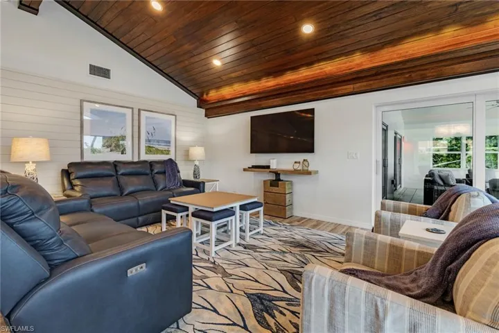 Living room with light hardwood / wood-style flooring, vaulted ceiling, and wood ceiling