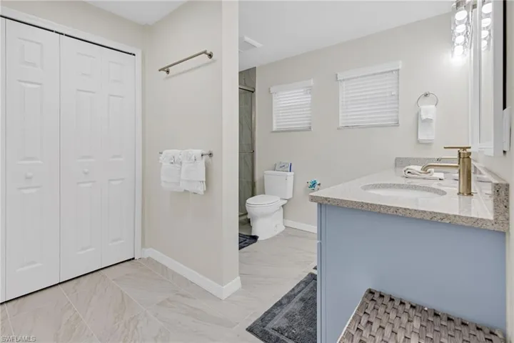 Bathroom with vanity, toilet, and an enclosed shower